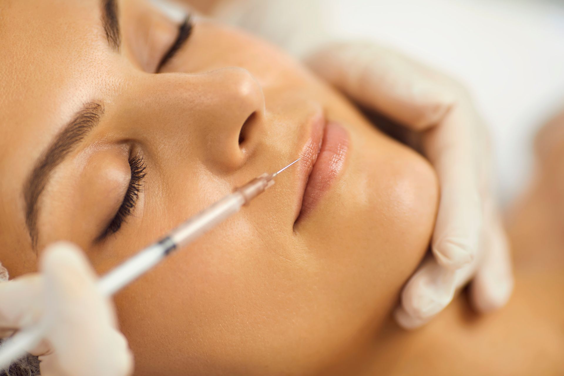 Eine Frau bekommt eine Botox-Injektion in die Lippen.