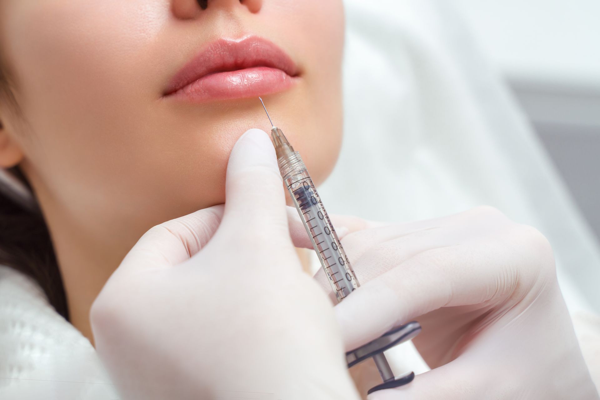 Eine Frau bekommt eine Botox-Injektion in die Lippe.
