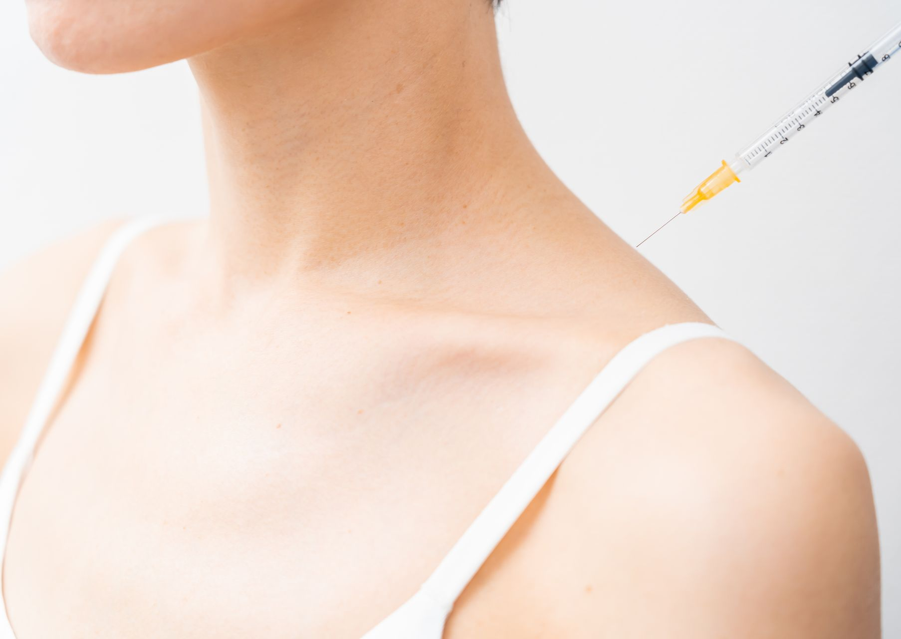 Eine Frau bekommt eine Spritze in die Schulter.