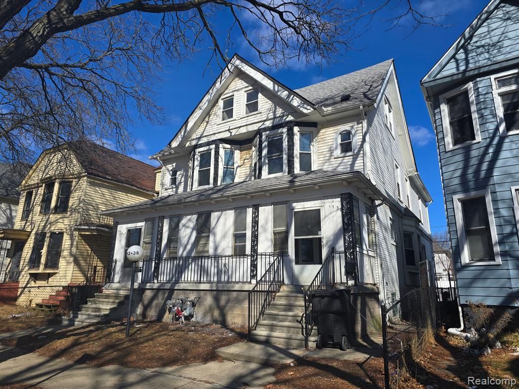 A white house is sitting next to a blue house on a sunny day.