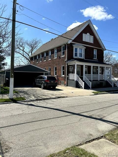 A large brick house with a car parked in front of it
