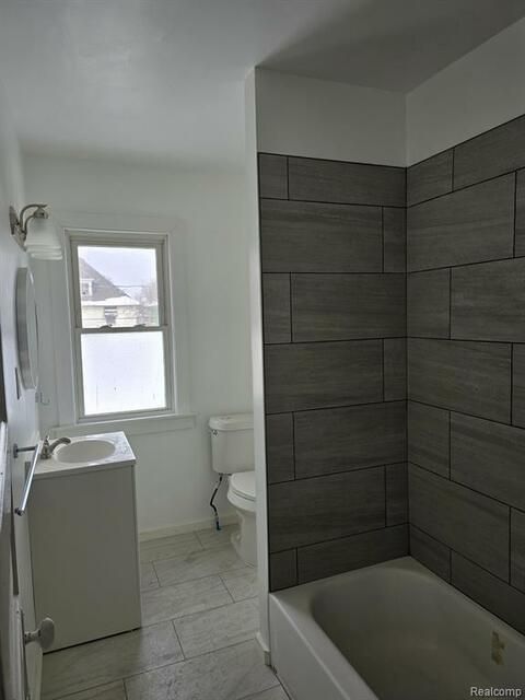 A bathroom with a sink , toilet , and bathtub.