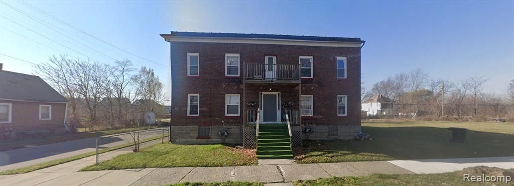 A large brick building with a green staircase in front of it