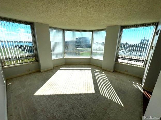 An empty room with a lot of windows and blinds.