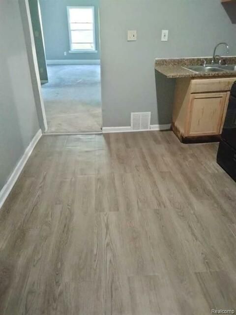 A kitchen with hardwood floors and a stove.