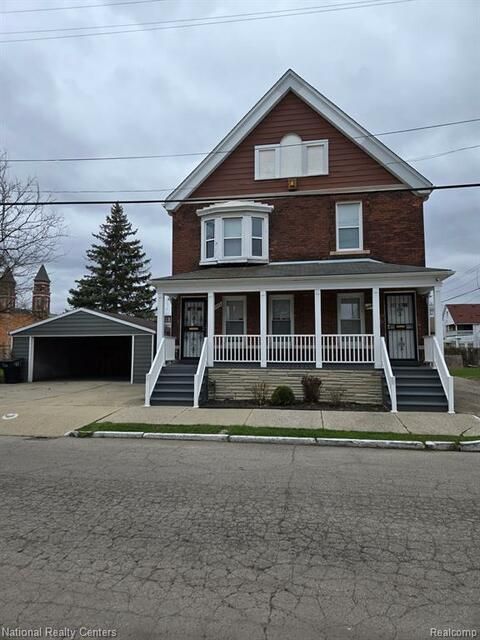 A large brick house with a porch and stairs is for sale.