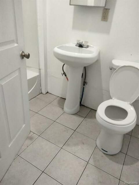 A bathroom with a toilet a sink and a bathtub