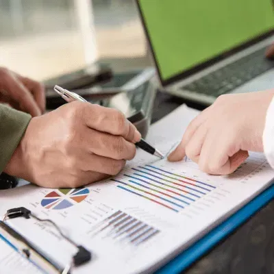 A person is writing on a piece of paper with a pen.