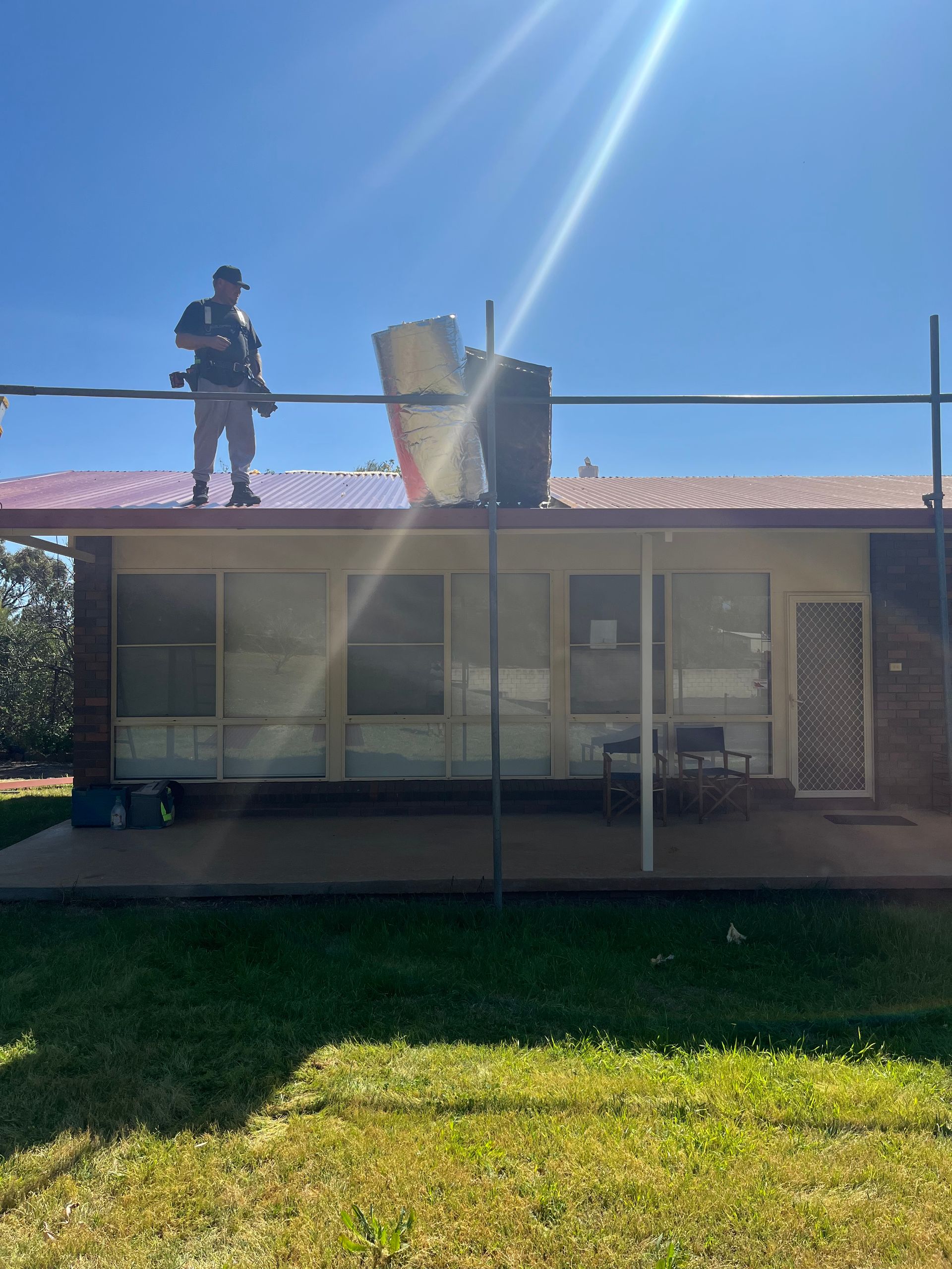 Worker on Roof repairing it — Roofer in Forbes, NSW