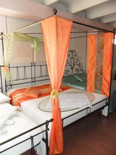 un letto a baldaccchino con tende arancioni