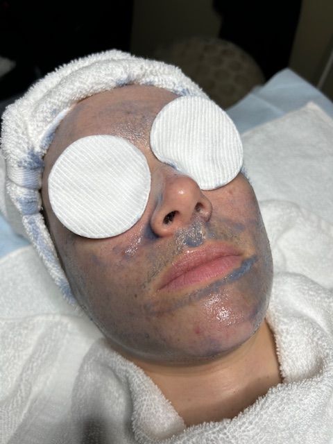 A woman is laying on a bed with a mask on her face.