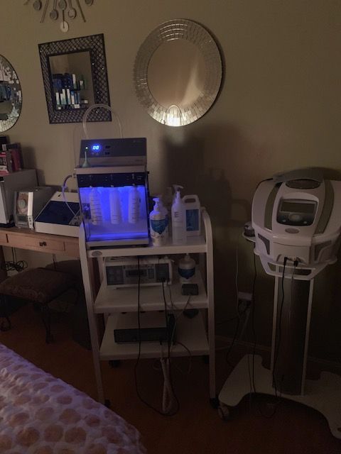 A room with a bed , mirrors , and a table with a laptop on it.