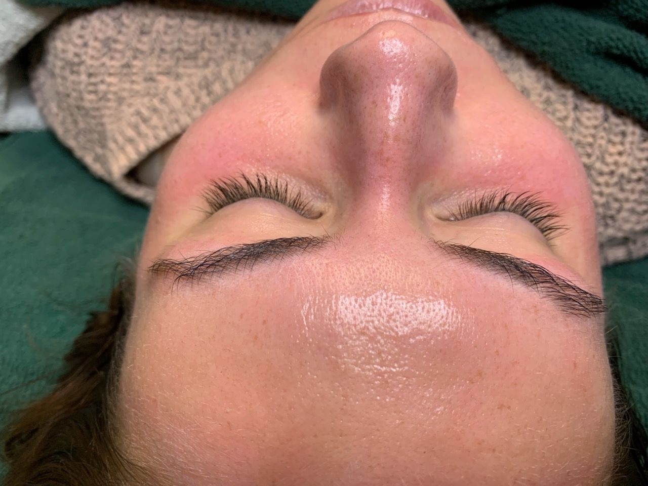 A close up of a woman 's face with her eyes closed.