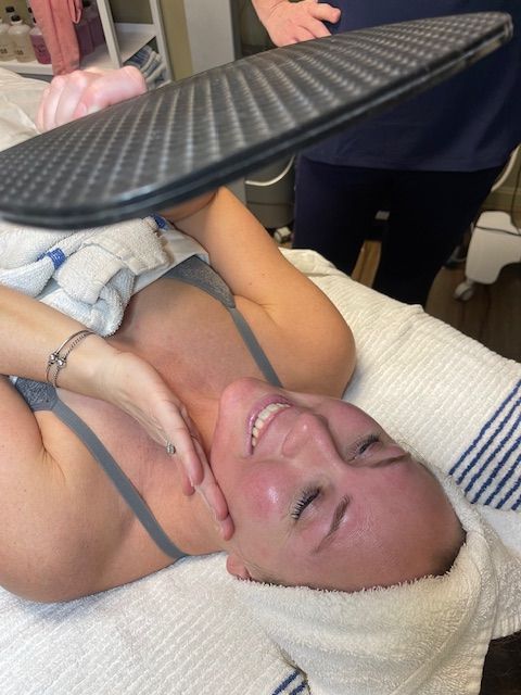 A woman laying on her back with a towel on her head