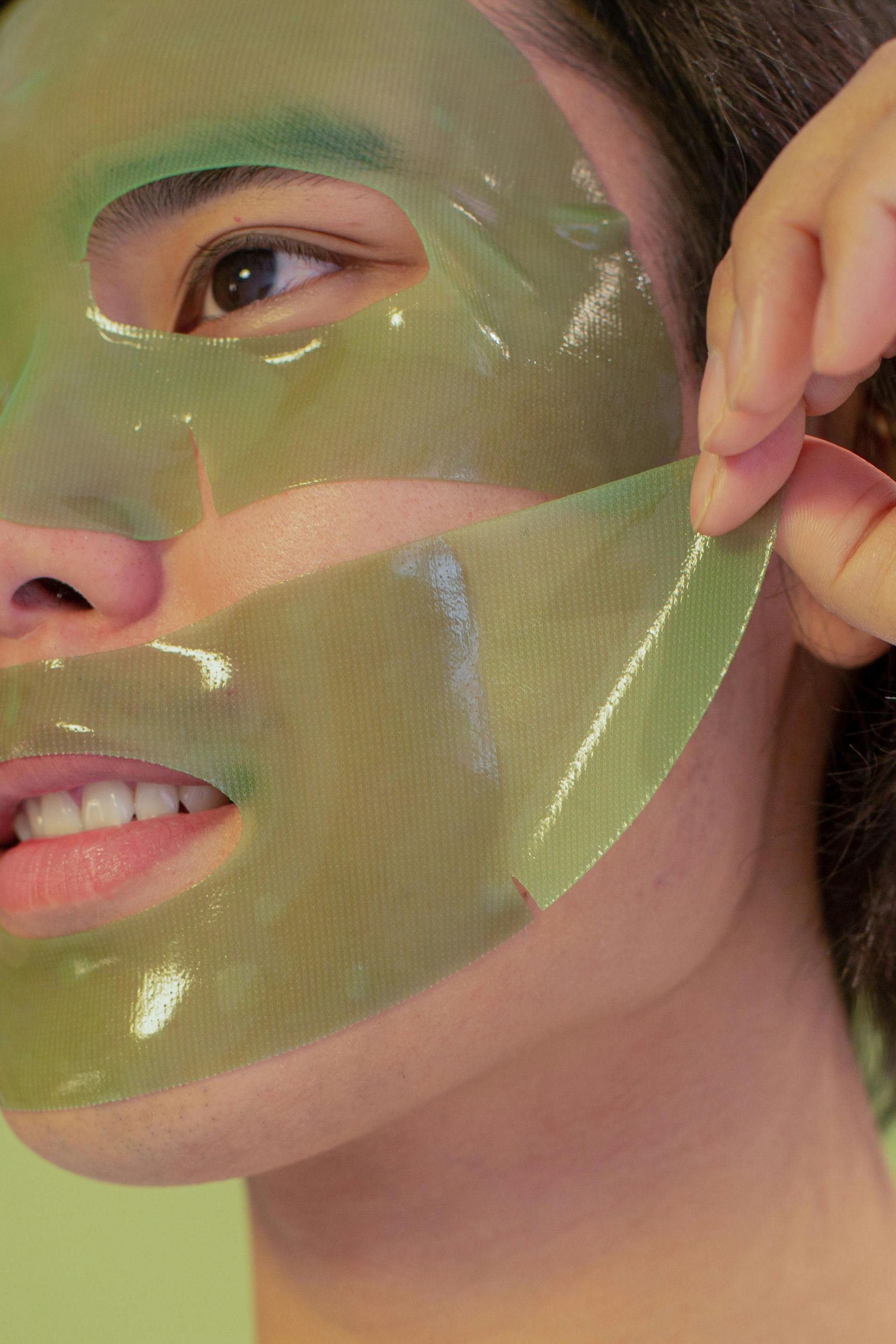 A close up of a person wearing a green mask on their face.