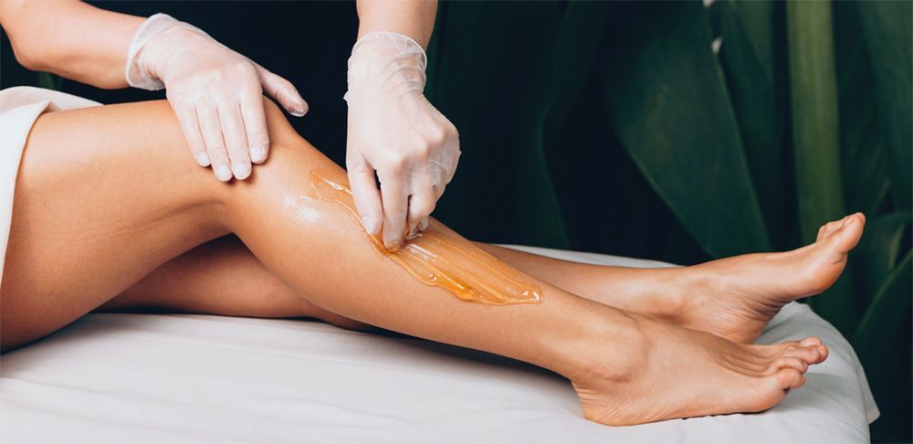 A woman is getting her legs waxed in a beauty salon.