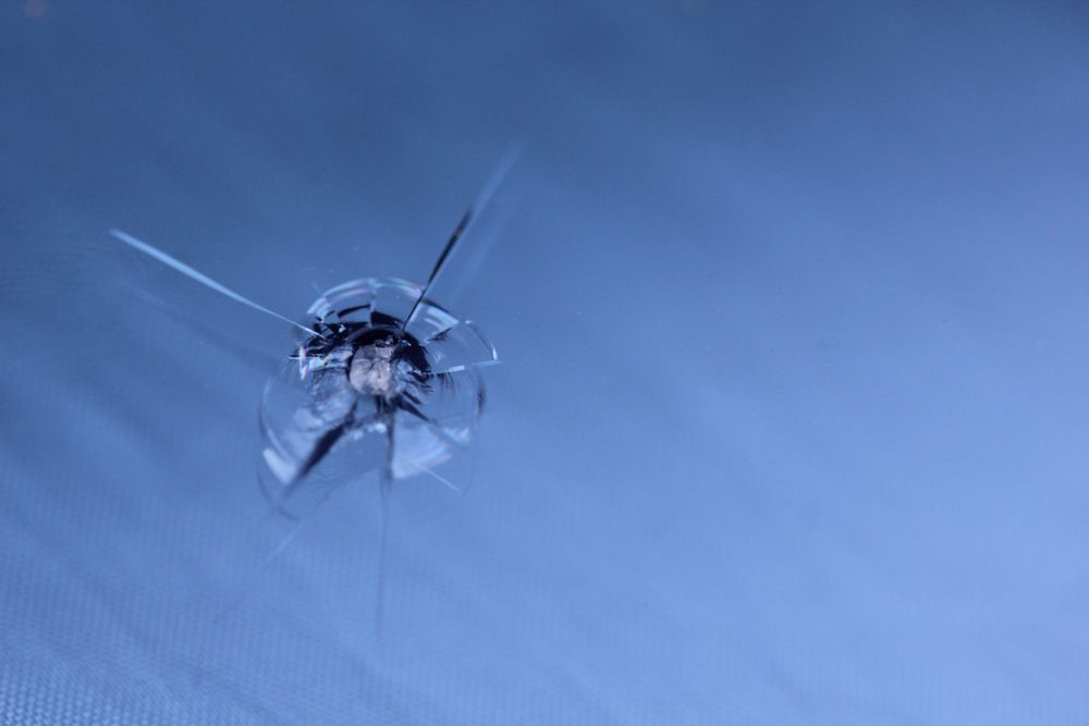a Close Up of a Cracked Windshield With a Hole in It — Innisfail Glass & Aluminium In Tully, QLD