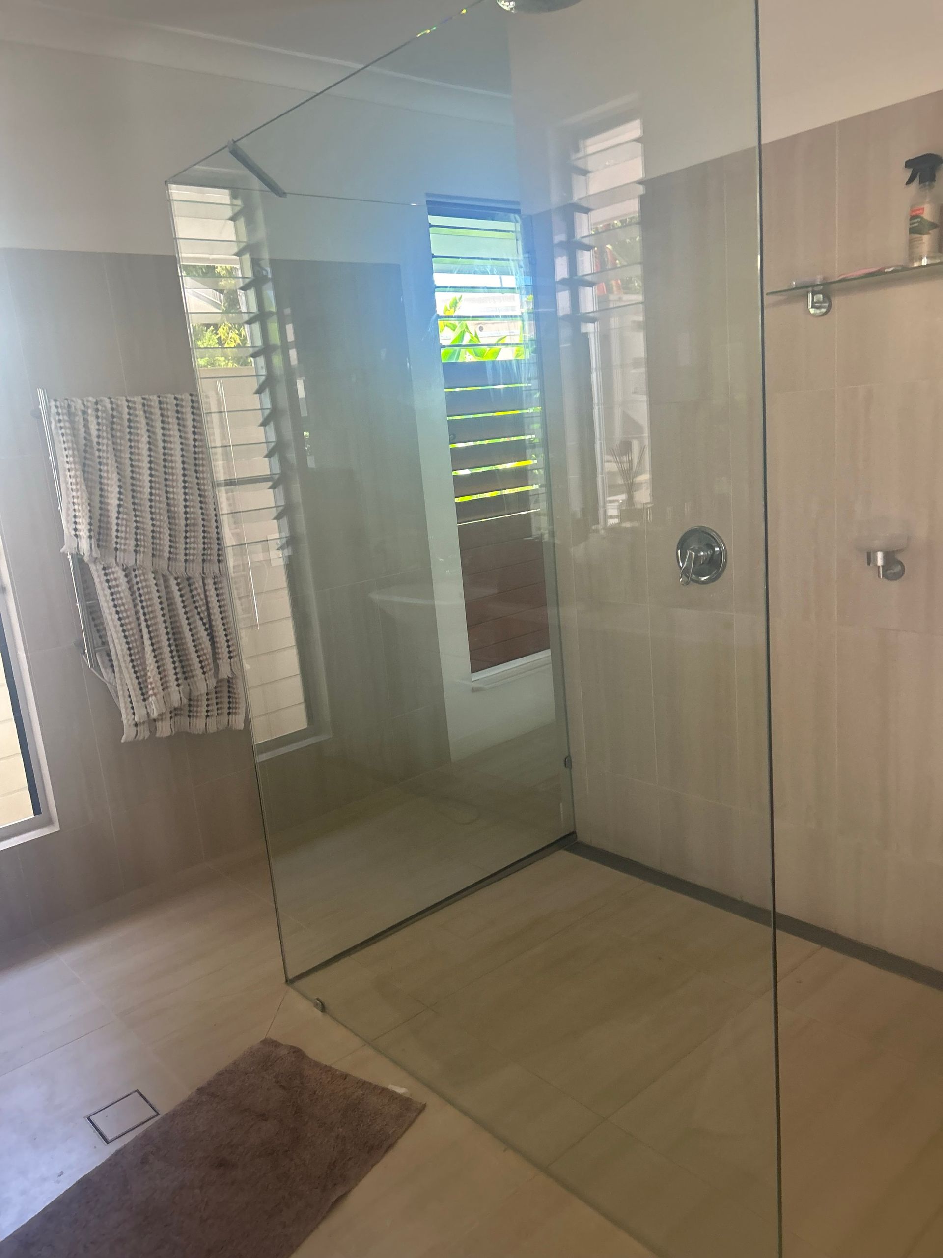 A bathroom with a walk in shower and a window — Innisfail Glass & Aluminium In Innisfail, QLD