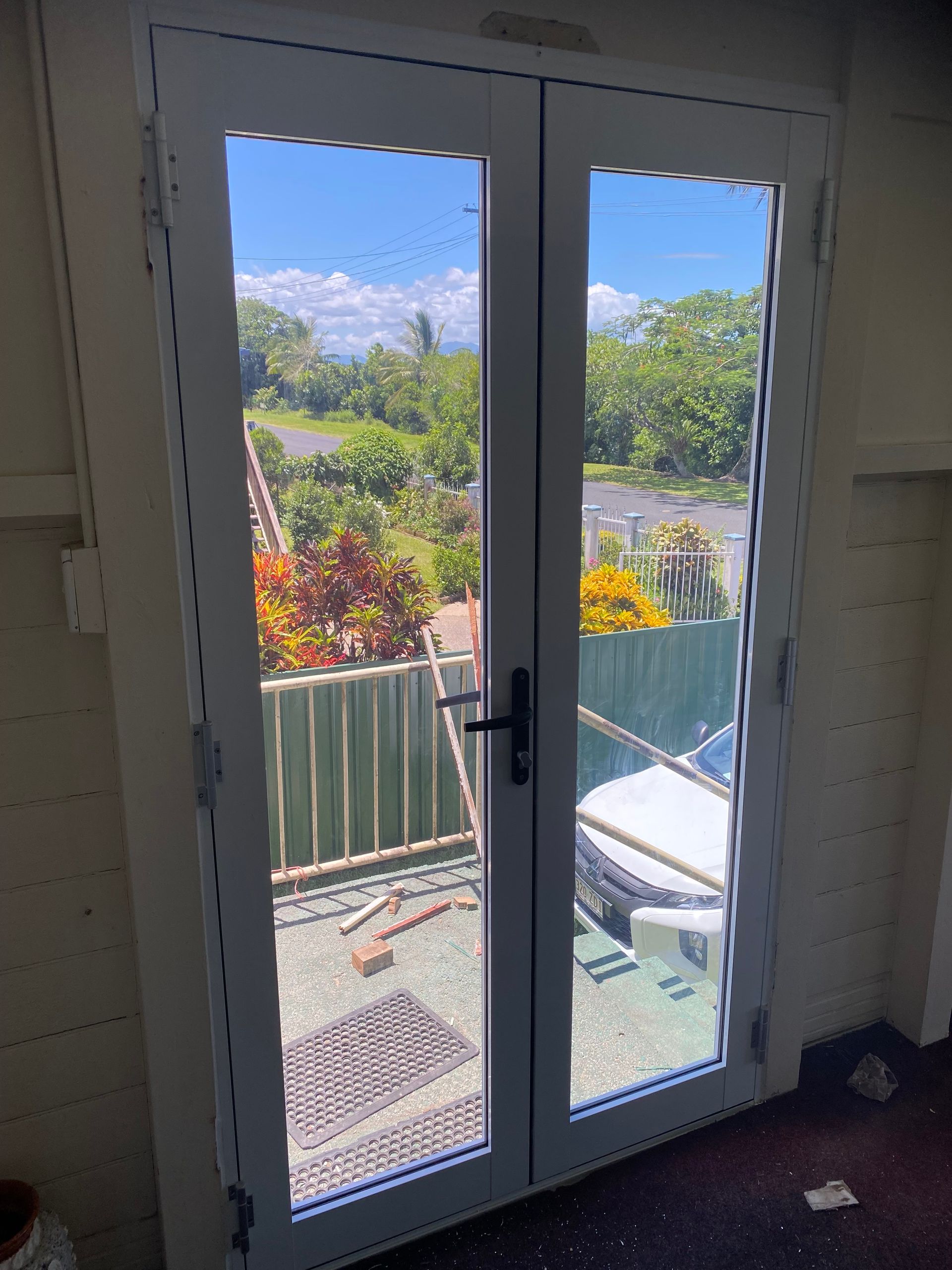 A pair of sliding glass doors with a view of a garden — Innisfail Glass & Aluminium In Innisfail, QLD
