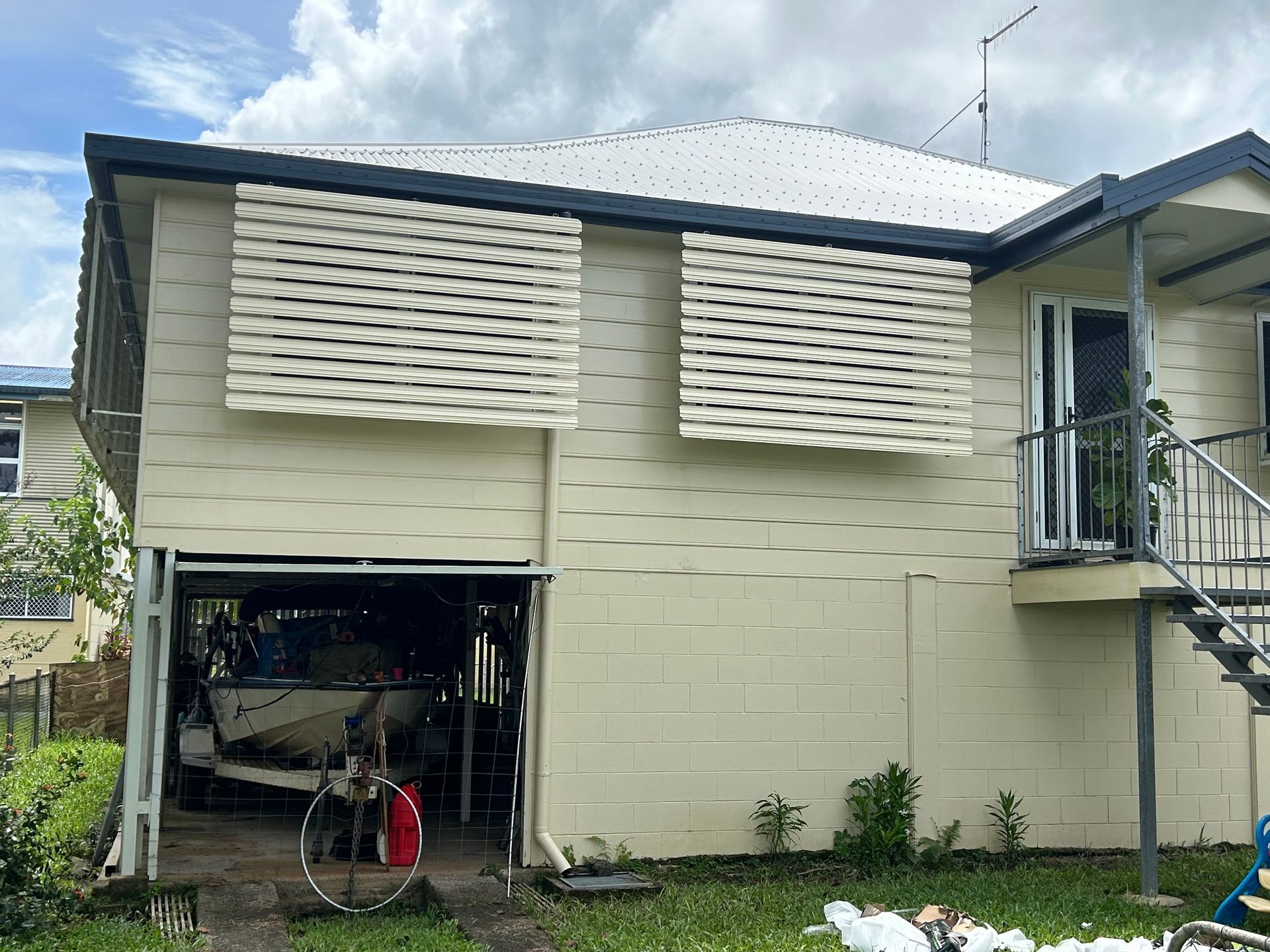 A boat is sitting in a garage next to a house — Innisfail Glass & Aluminium In Innisfail, QLD