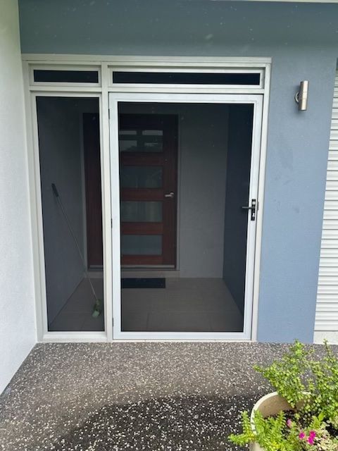 A house with a screen door and a potted plant in front of it — Innisfail Glass & Aluminium In Innisfail, QLD