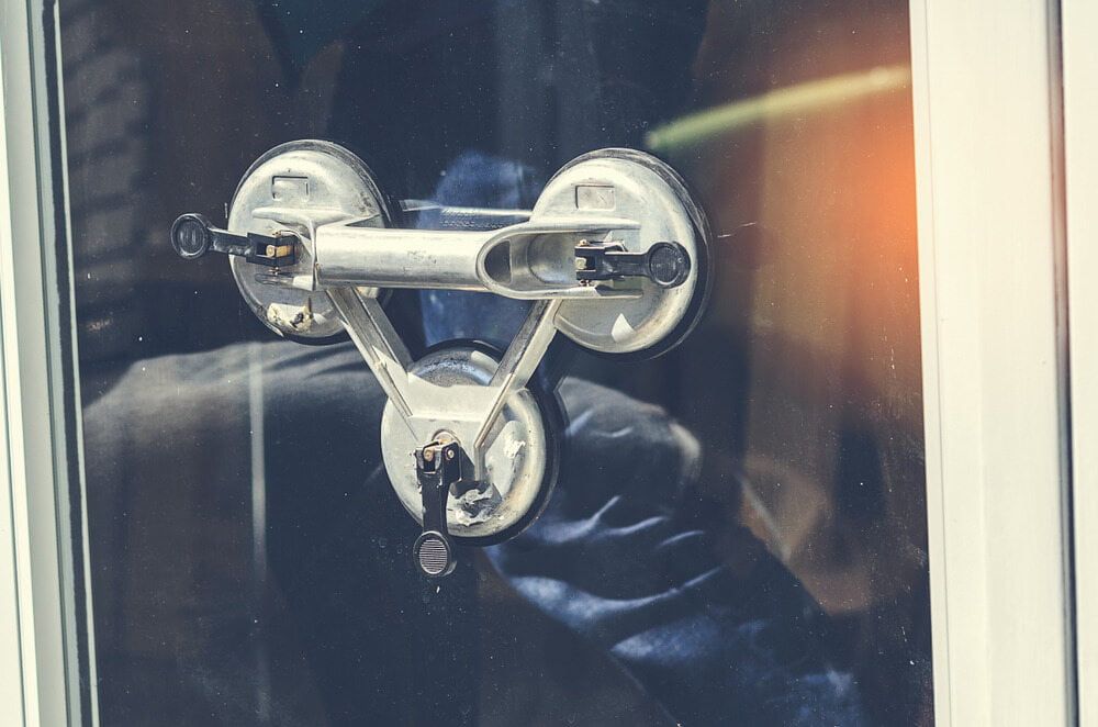 a Person is Installing a Glass Window With a Suction Cup — Innisfail Glass & Aluminium In Mission Beach, QLD