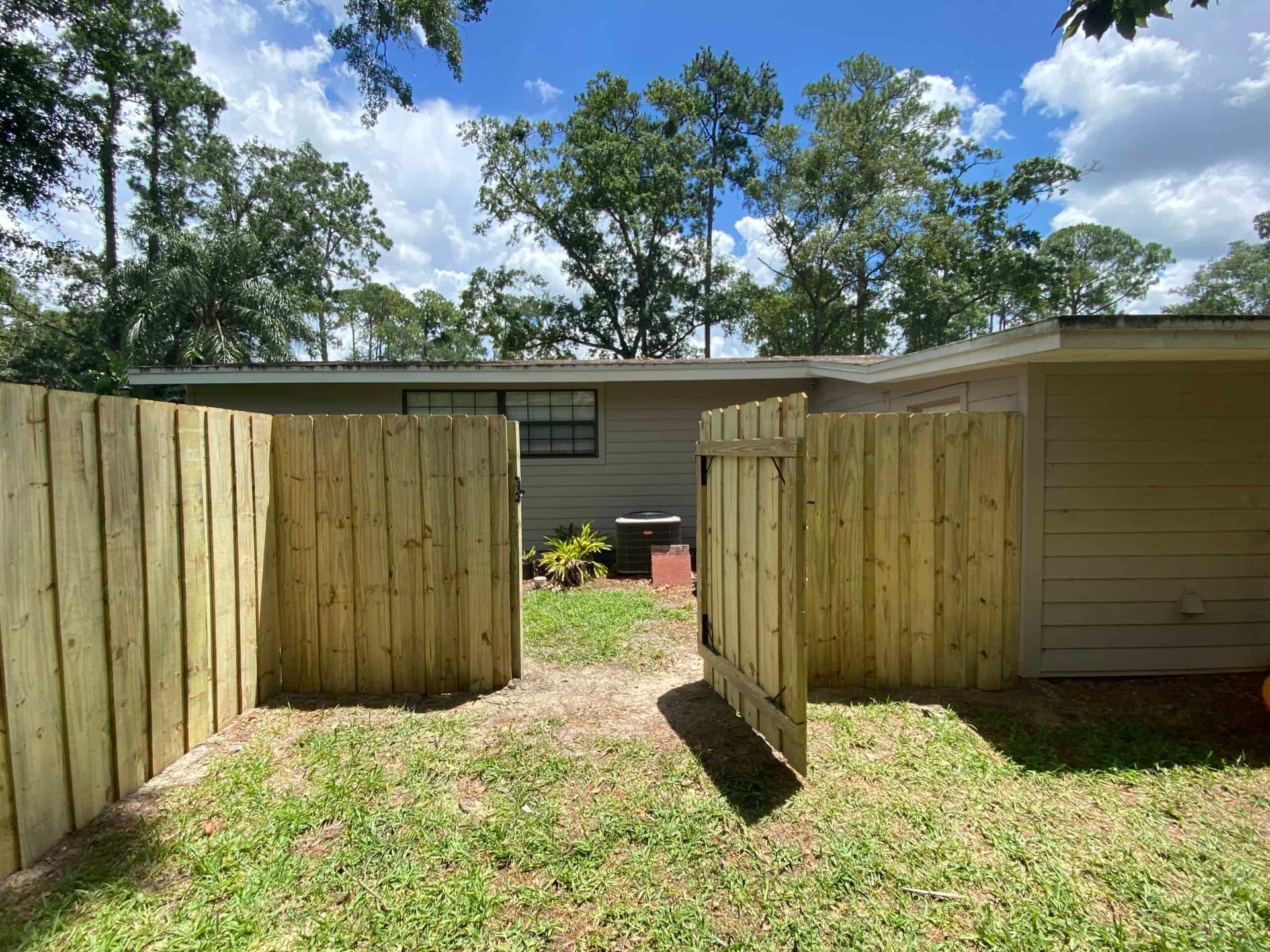 There is a wooden fence in the backyard of a house.