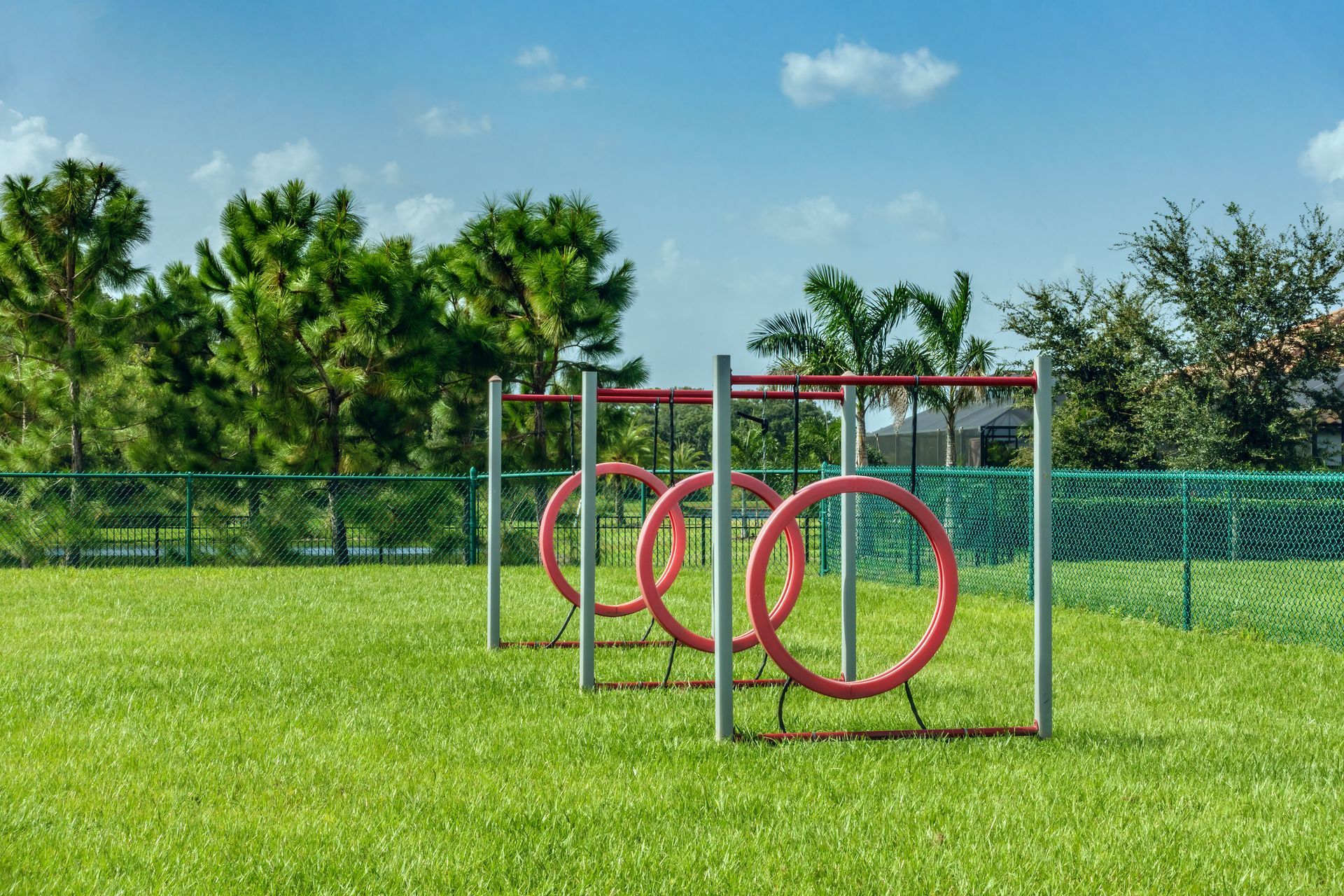 A row of red tires are sitting on top of a lush green field.