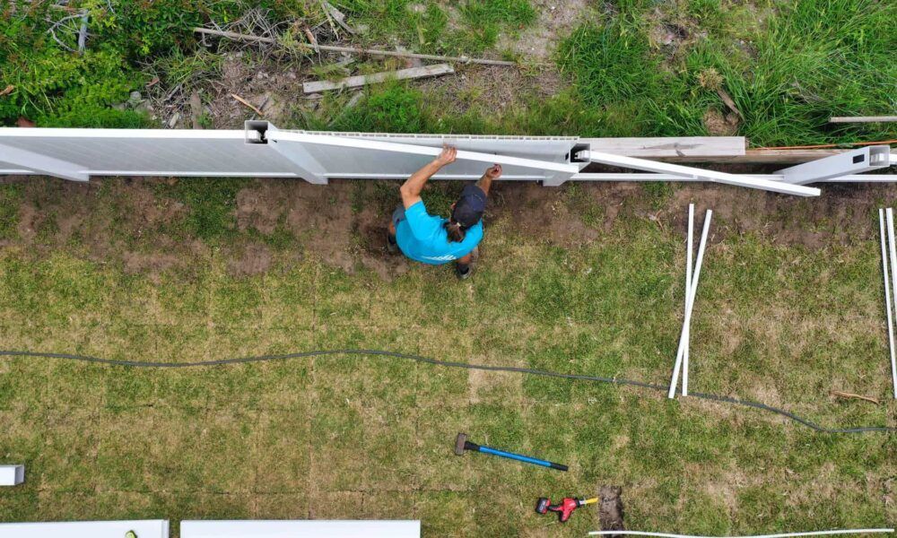 An aerial view of a man installing a fence in a yard.