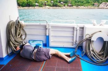 distressed person on a boat in the middle of the ocean