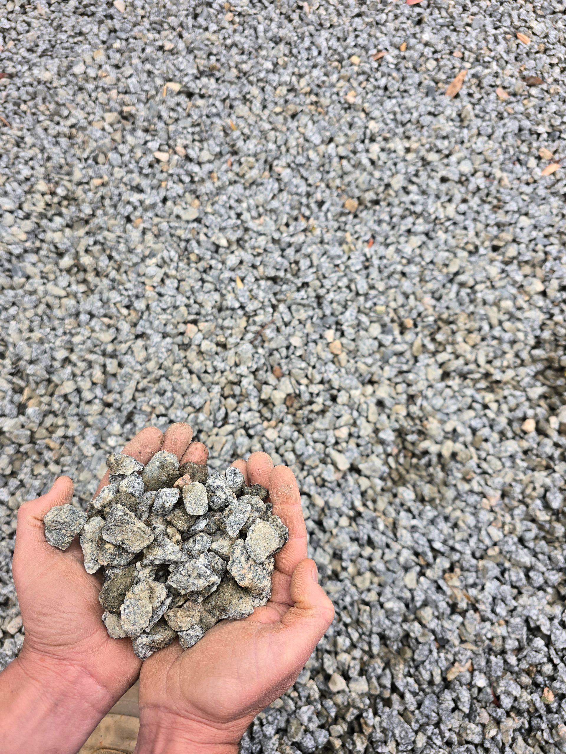 Hands Holding a Pile of Gray Gravel — BVN Landscape & Steel Supplies in St Georges Basin, NSW