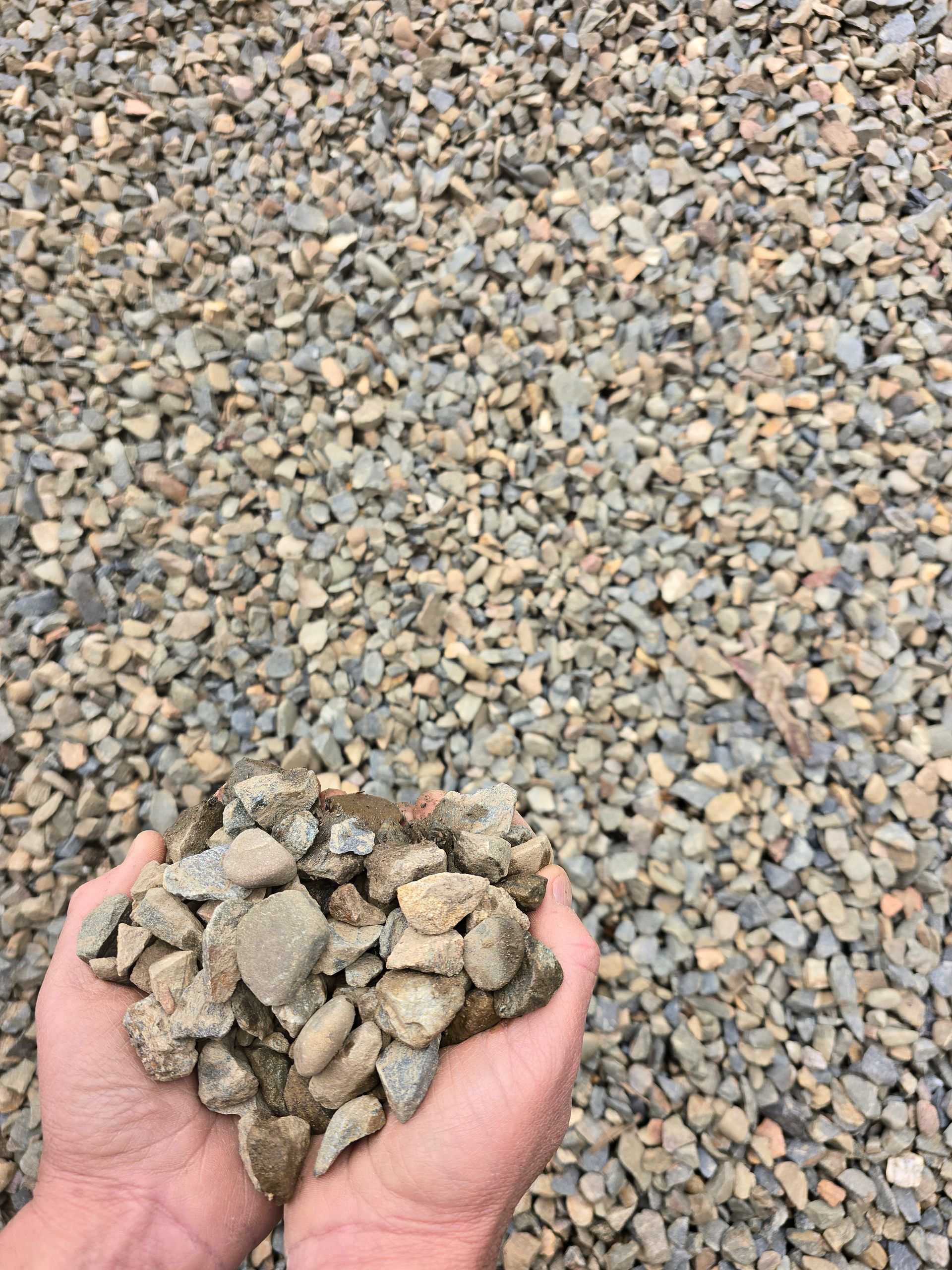 Hands Holding a Pile of Gravel, With More Gravel Filling the Frame — BVN Landscape & Steel Supplies in St Georges Basin, NSW