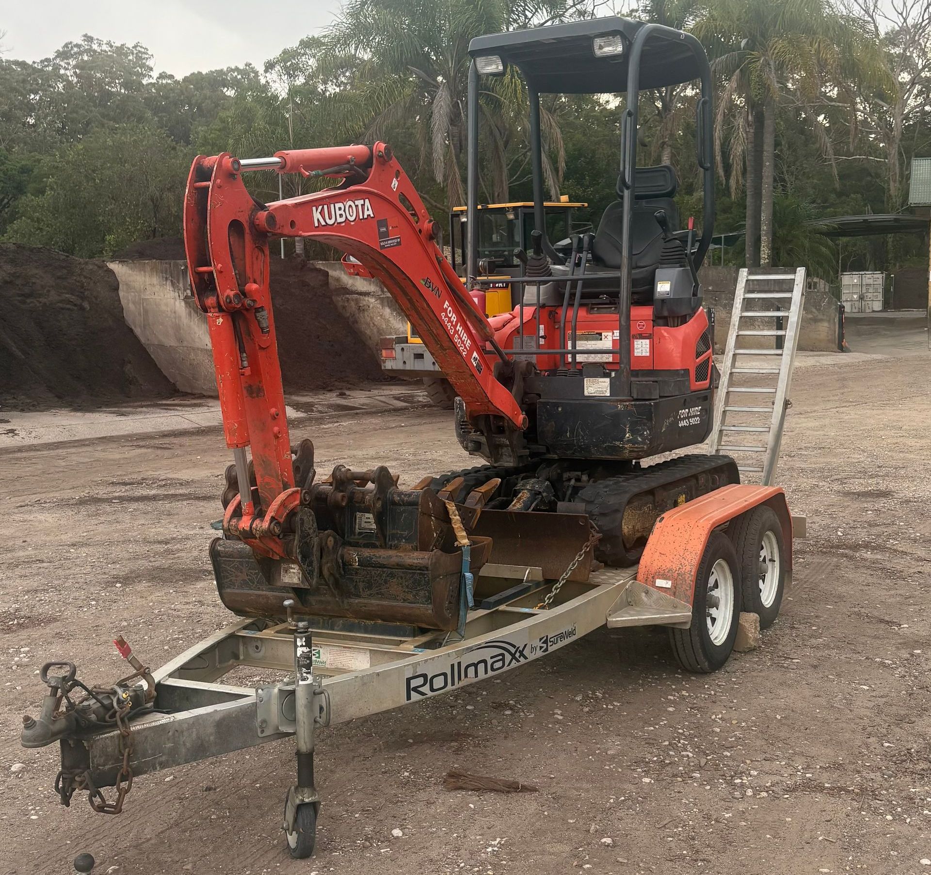 A Small Orange Excavator Is Parked Next to A Large Orange Excavator — BVN Landscape & Steel Supplies in St Georges Basin, NSW