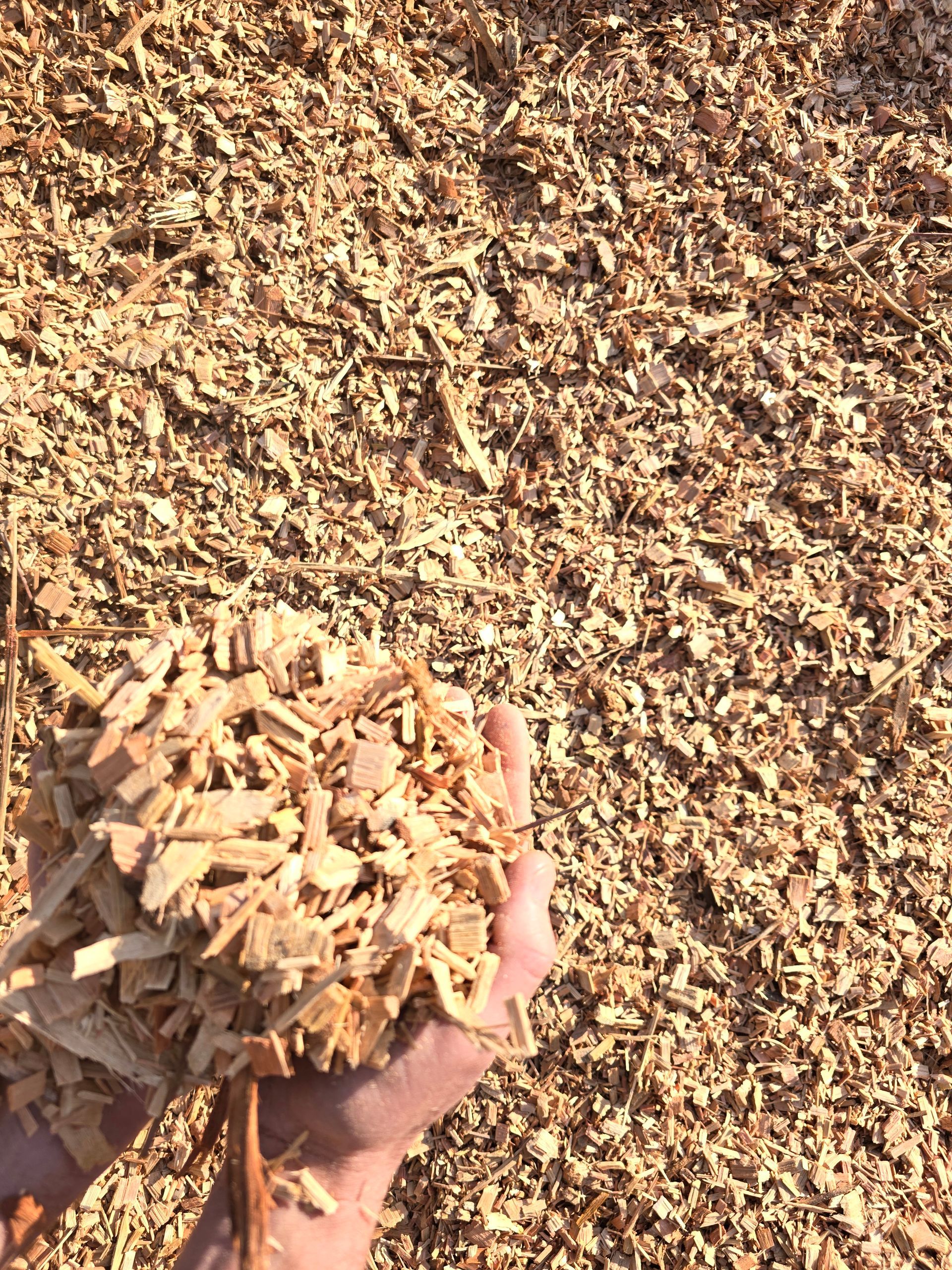 Hand Holding a Pile of Wood Chips — BVN Landscape & Steel Supplies in St Georges Basin, NSW