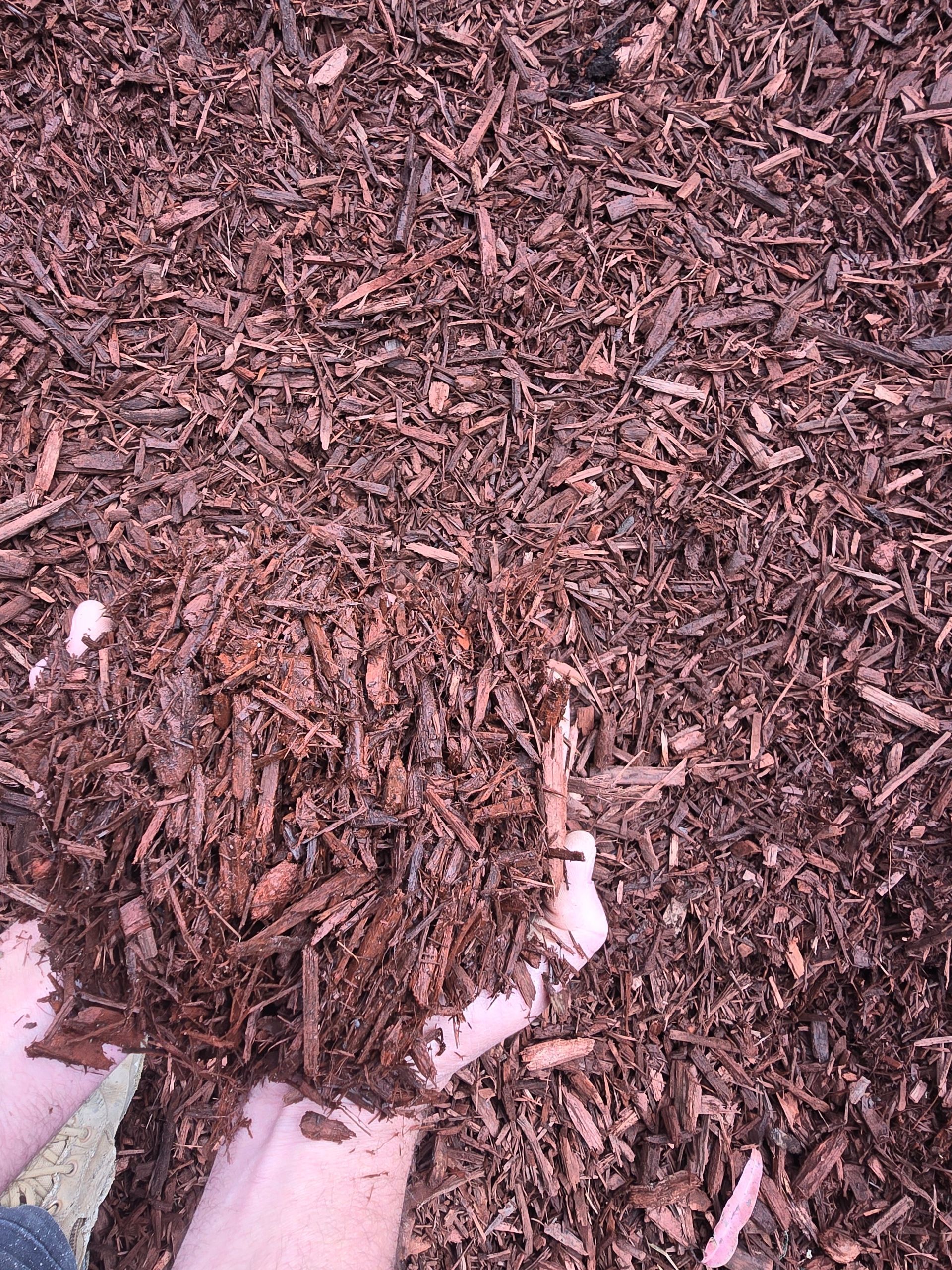 Hands Holding Dark Brown Mulch — BVN Landscape & Steel Supplies in St Georges Basin, NSW