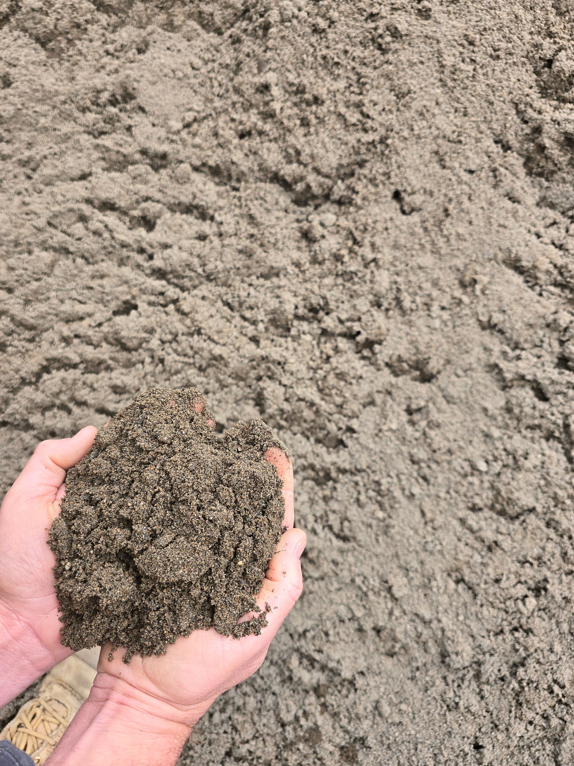 Hands Cupped Holding a Handful of Light Brown Sand — BVN Landscape & Steel Supplies in Vincentia, NSW