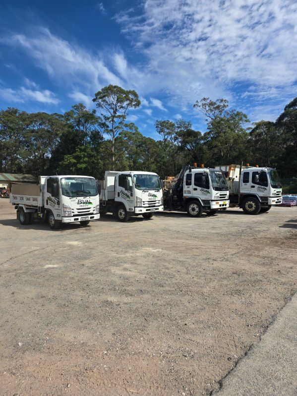 Five White Work Trucks Parked on a Gravel Lot — BVN Landscape & Steel Supplies in Ulladulla, NSW