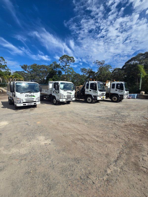 Five White Work Trucks Parked on a Gravel Lot — BVN Landscape & Steel Supplies in St Georges Basin, NSW