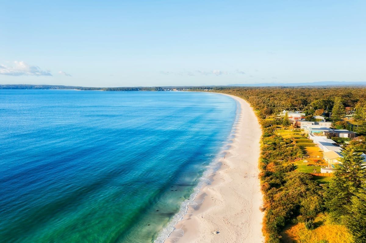 Aerial View of a Sandy Beach Beside Clear Blue Ocean — BVN Landscape & Steel Supplies in Callala Beach, NSW
