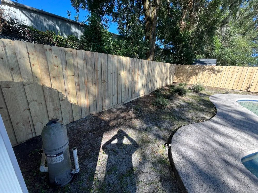 Wooden fence and curved concrete pool deck