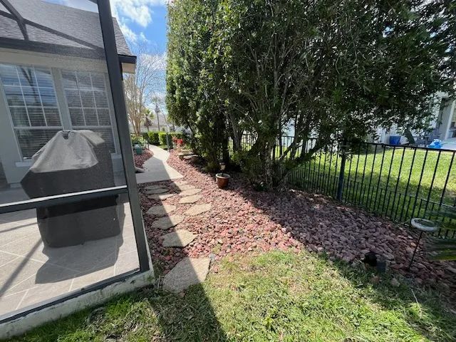 A stone path leads alongside a screened porch