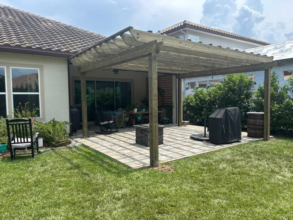 A wooden pergola covers a stone patio