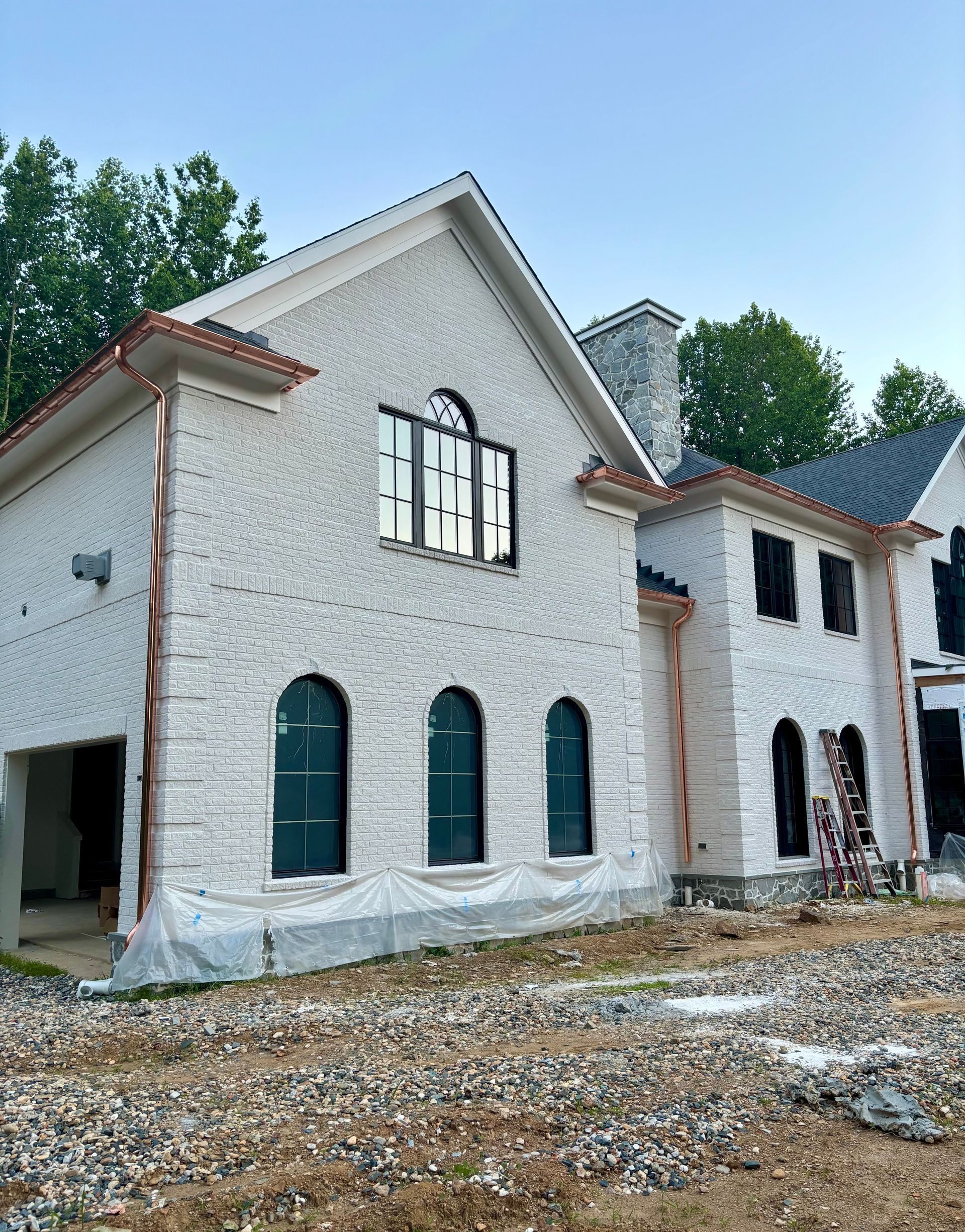 A copper gutter is being installed on the roof of a house.