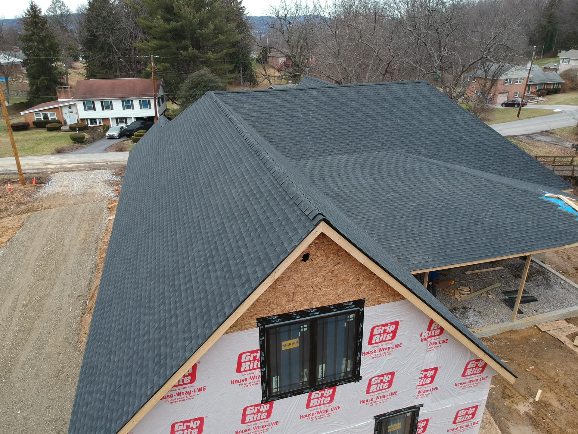 An aerial view of a house under construction with a black roof