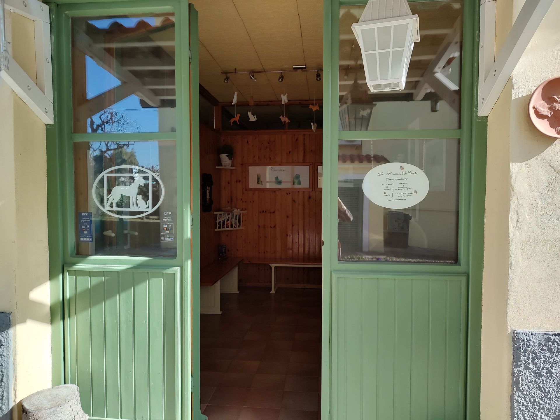 Una porta verde con un cane sopra è aperta su una stanza.