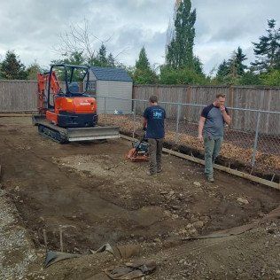A man is standing next to a bulldozer on a dirt road.