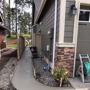 A concrete walkway is being built in front of a house.