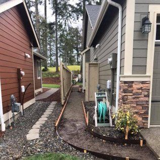 A sidewalk is being built between two houses.