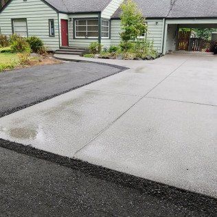 There is a concrete driveway in front of a house.