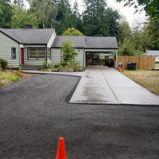 There is a concrete driveway in front of a house.